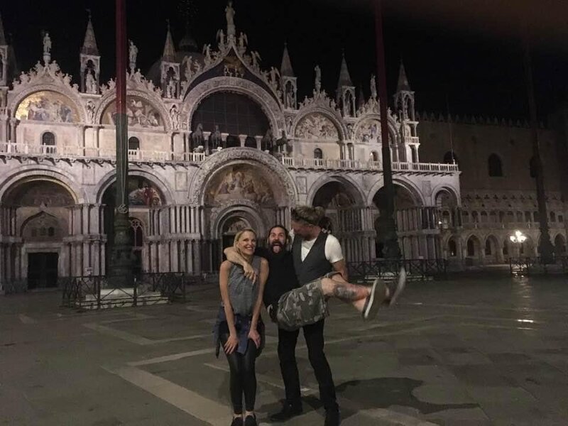 Group of friends joking around late at night in front of Basilica San Marco St Mark's Square in Venice 