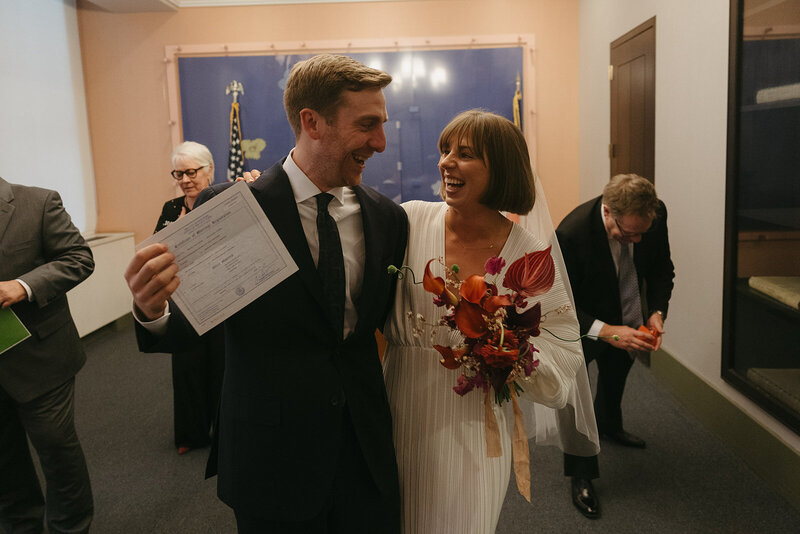 bride and groom with certificate at city hall after elopement ceremony shot by Elsie Goodman Photography | NYC Elopement Packages