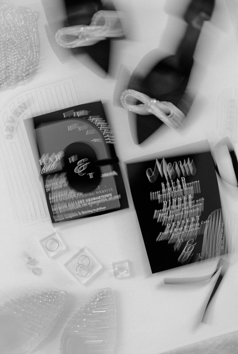 Blurred black and white image of a black, white, pearl, modern flat lay 