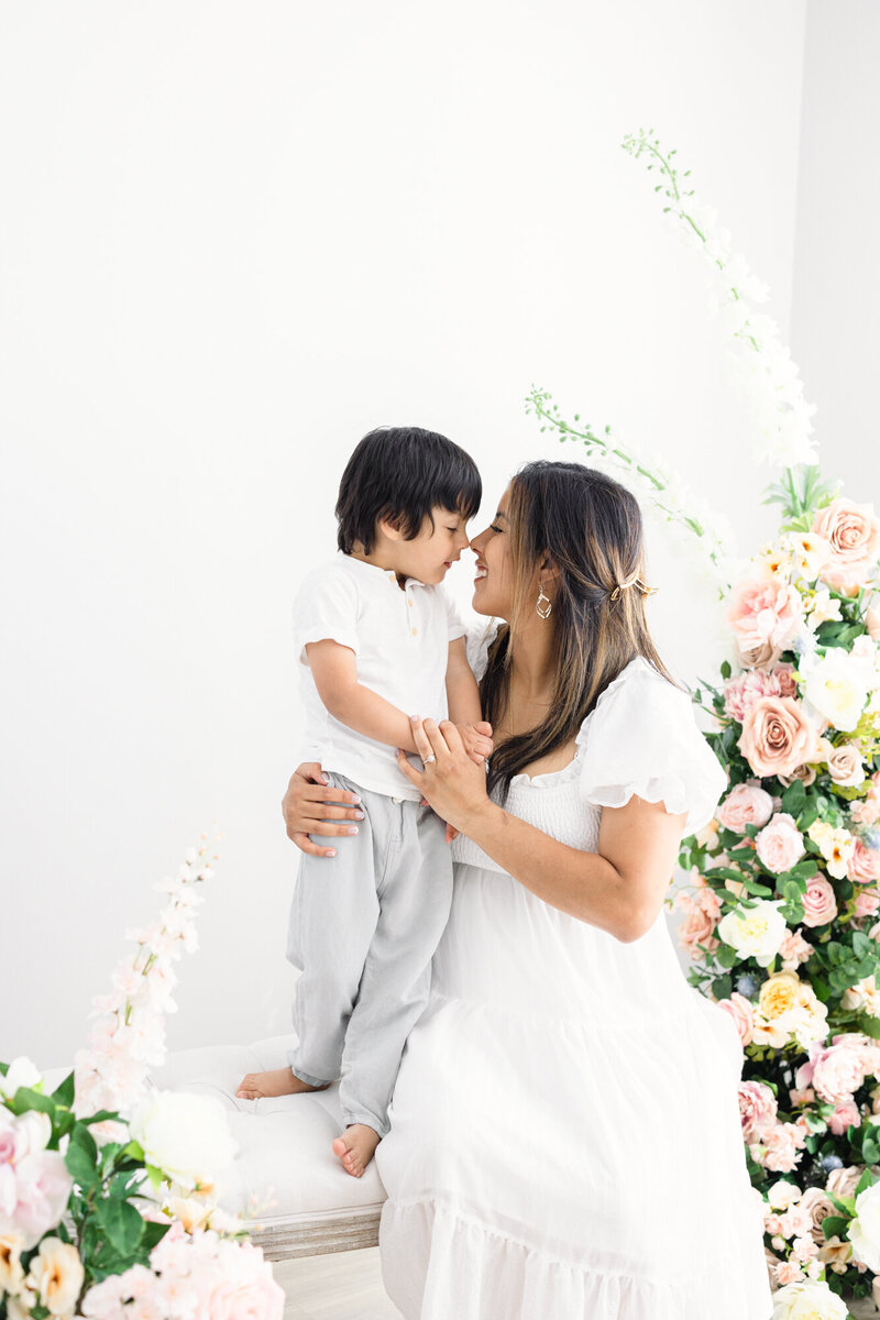 Mom and son dressed in white in a bright louisville kentucky family photography studio