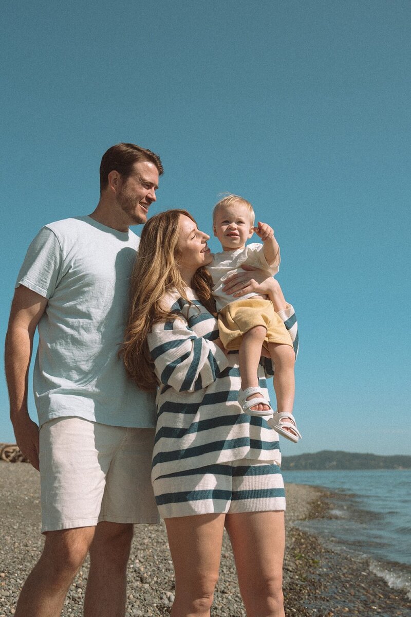 male and female standing on beach with little boy in sunlight