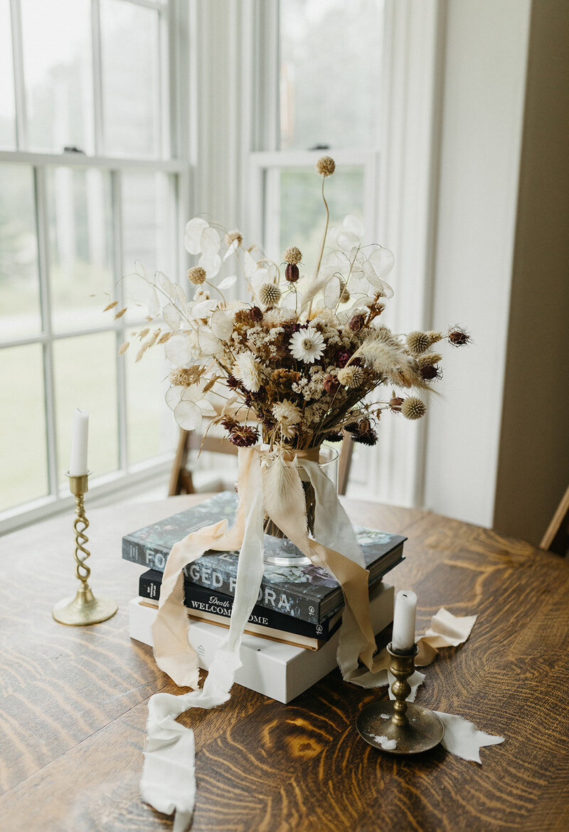 Floral bouquet sitting on top of books at New England Wedding