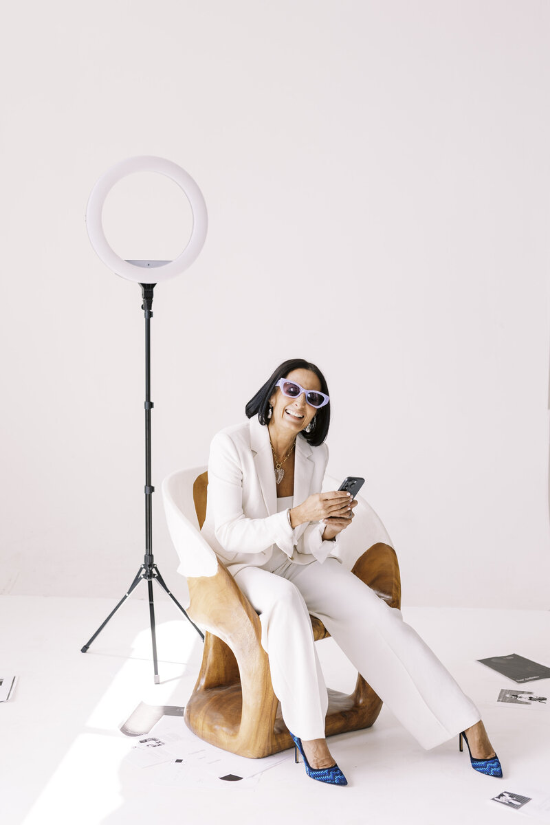 Tarah Baiman sitting in chair on set with paper scattered on floor