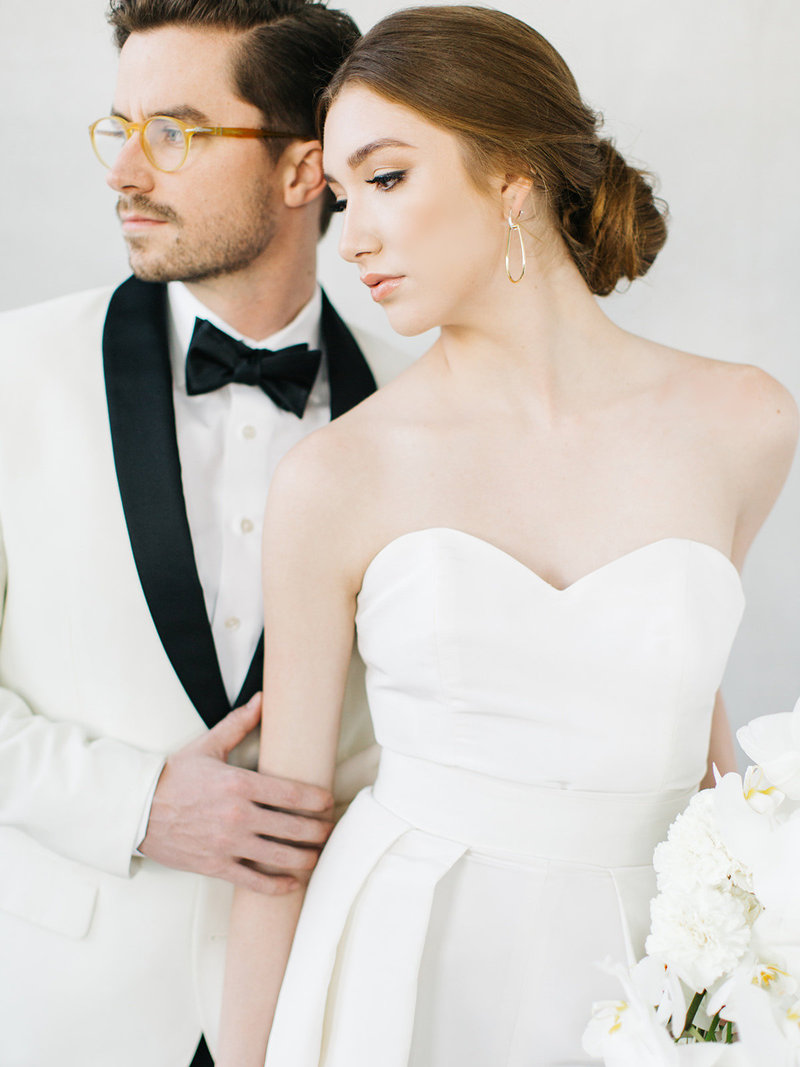 A destination wedding couple in wedding dress with removable cape and dinner jacket