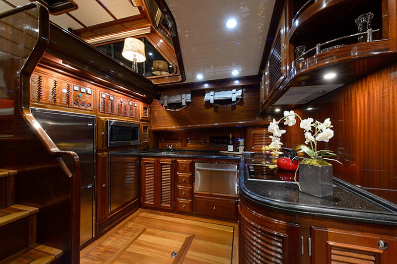 luxurious yacht kitchen with wooden cabinets, stainless steel appliances, and dark countertops