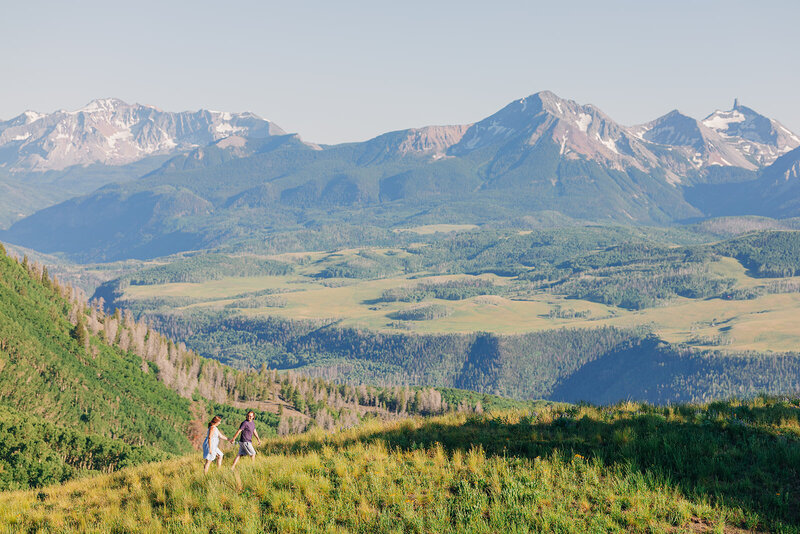 Couple walking in the mountains of Telluride with a mountain background.
