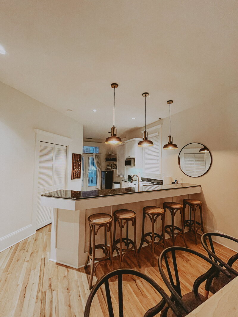 modern dining area with rattan barstools and pendant lighting