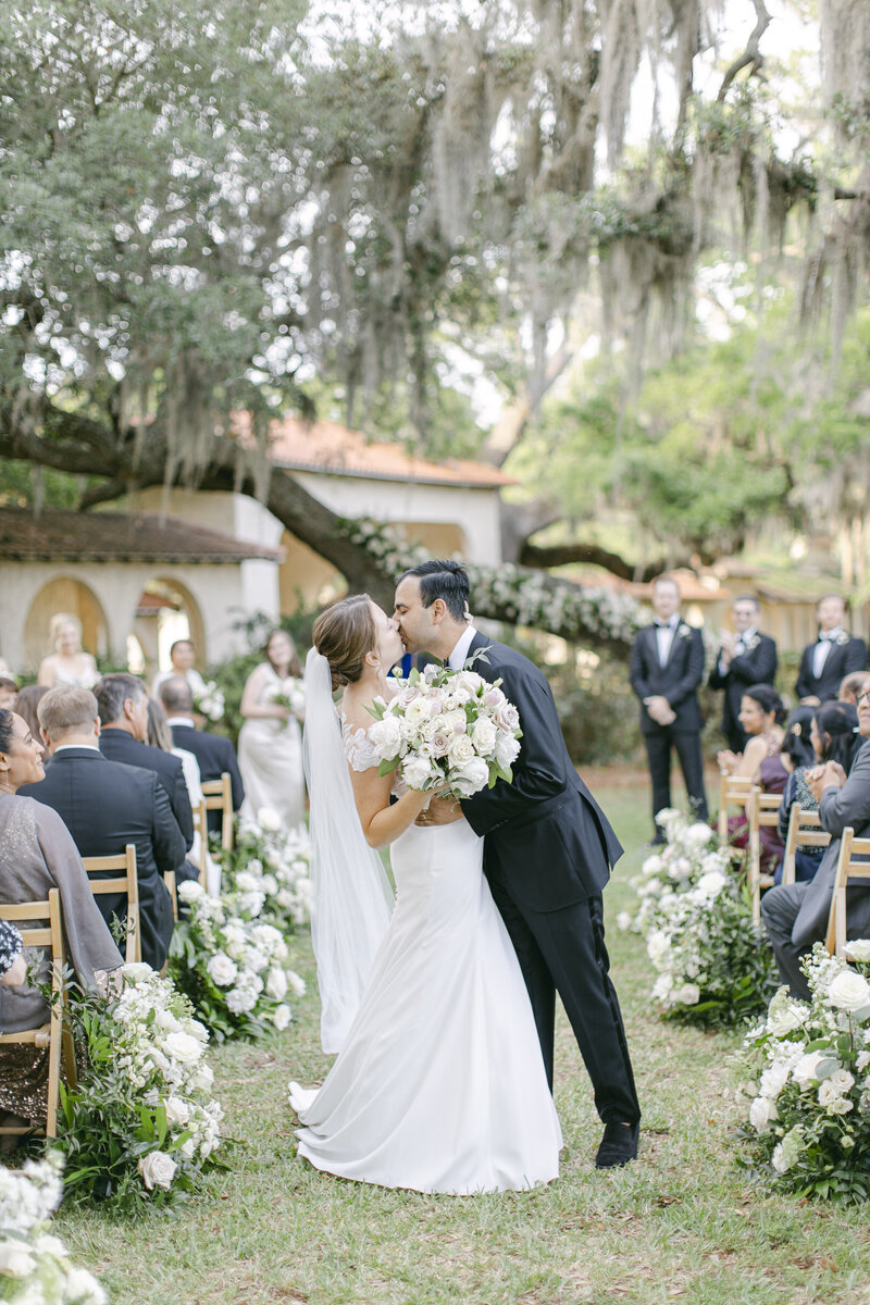 Groom kissing bride in the middle of aisle at 700 Wilmington.