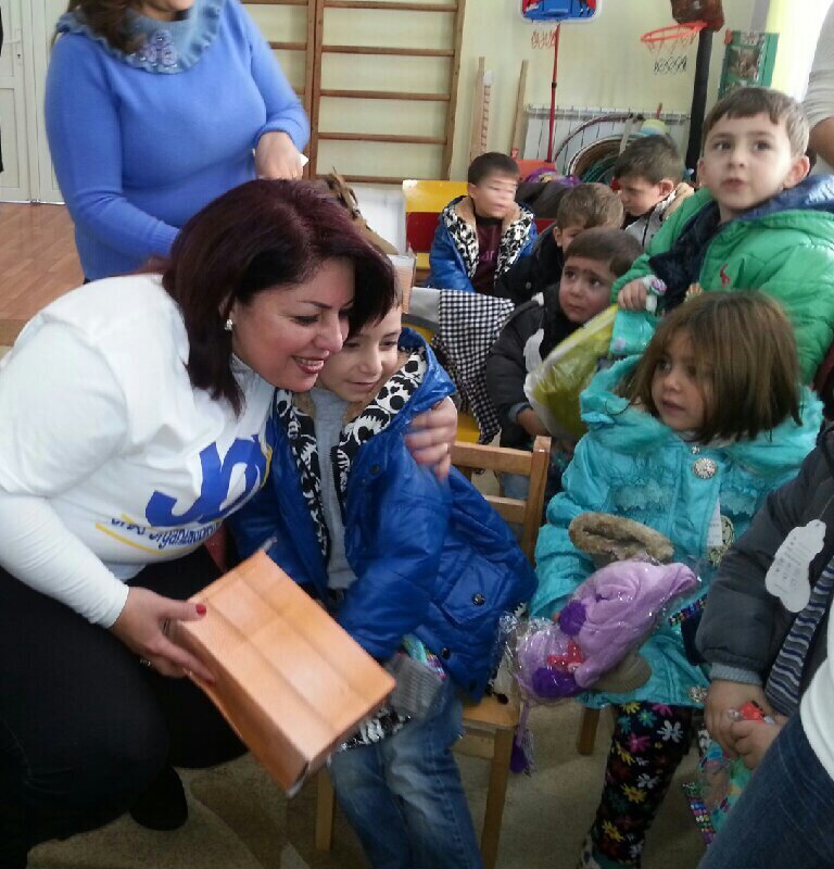 Volunteer helping children distribute toys during JOY outreach