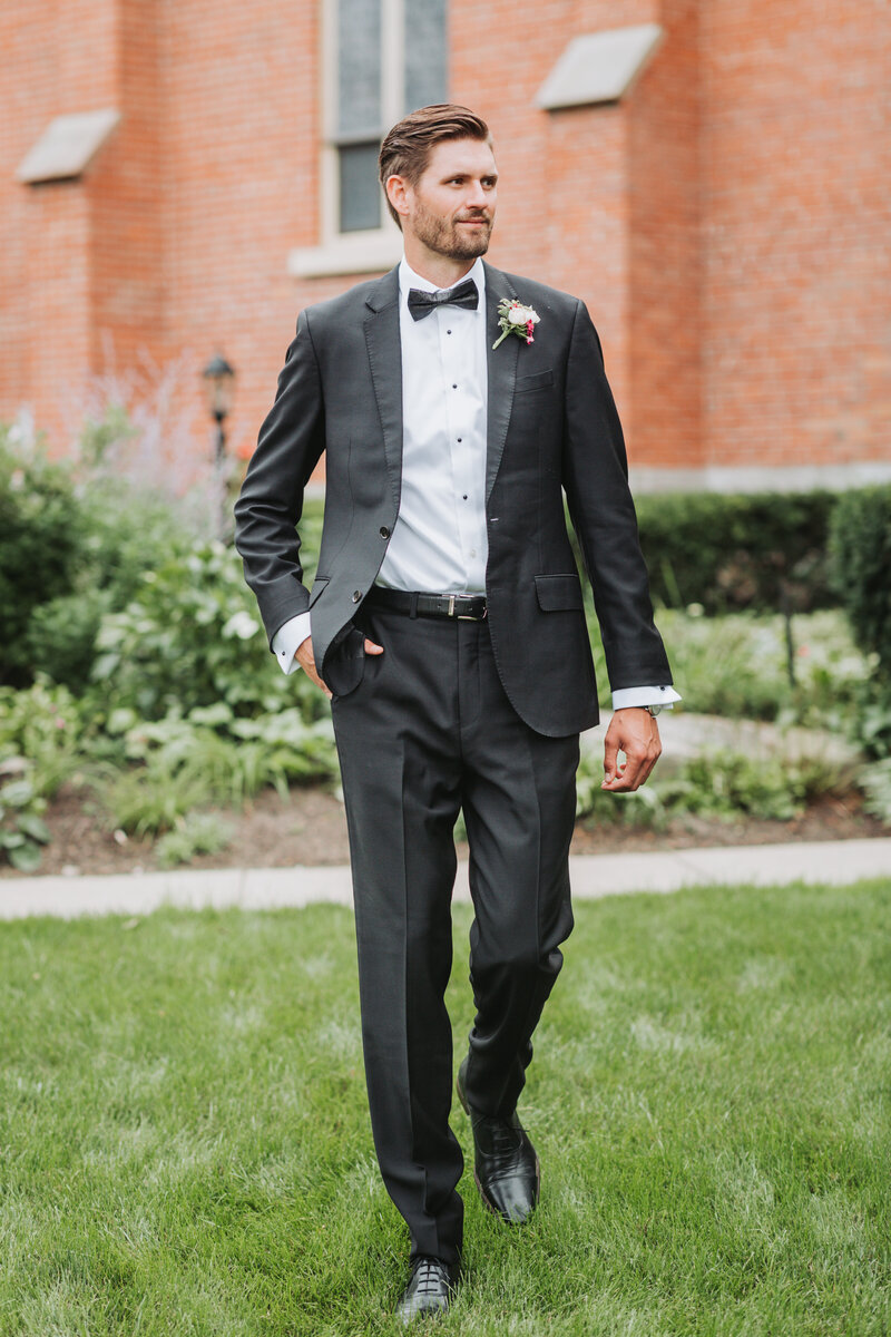Groom walking with one hand in his pocket