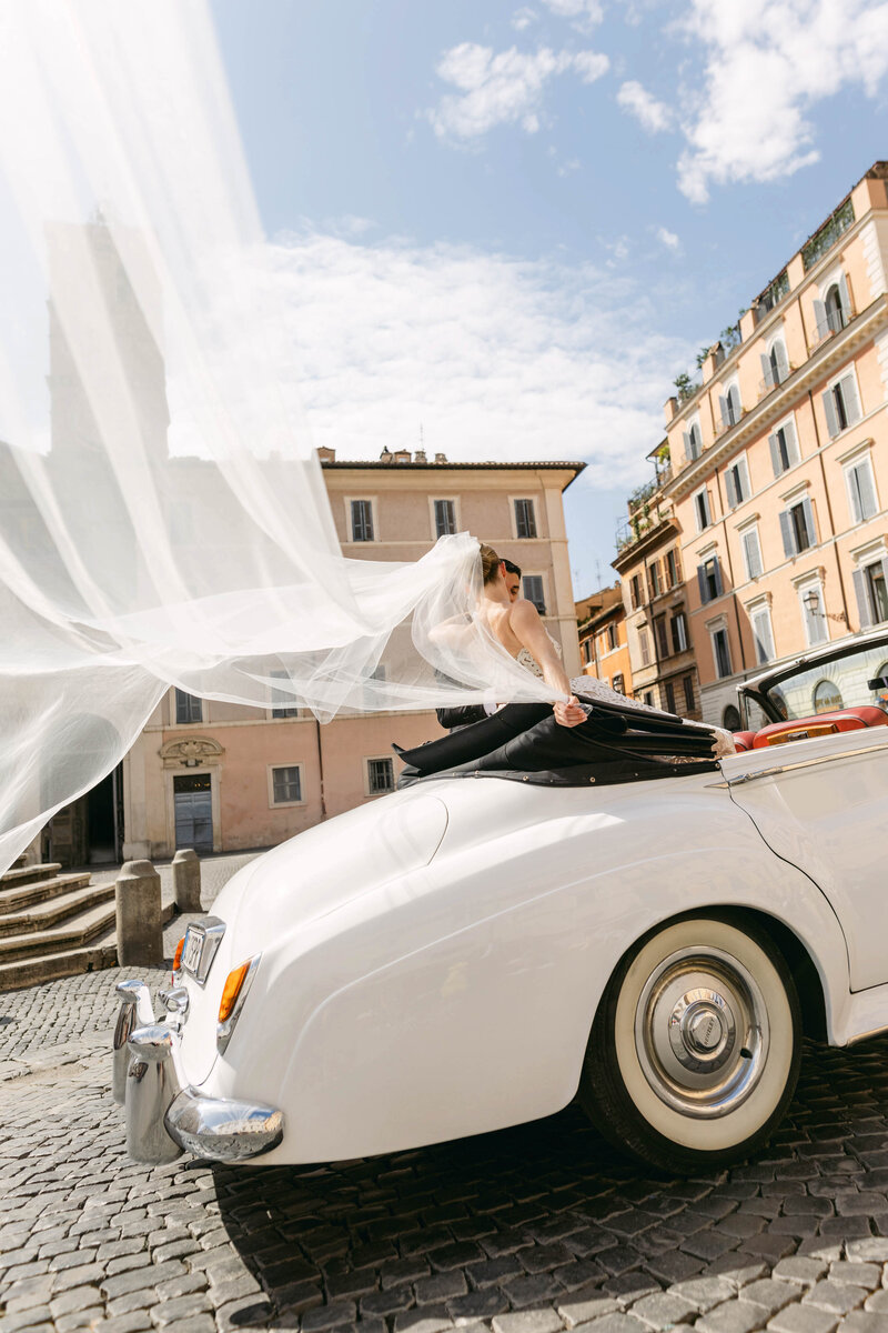 a bride and groom walking towards the camera after getting married, he kisses her hand