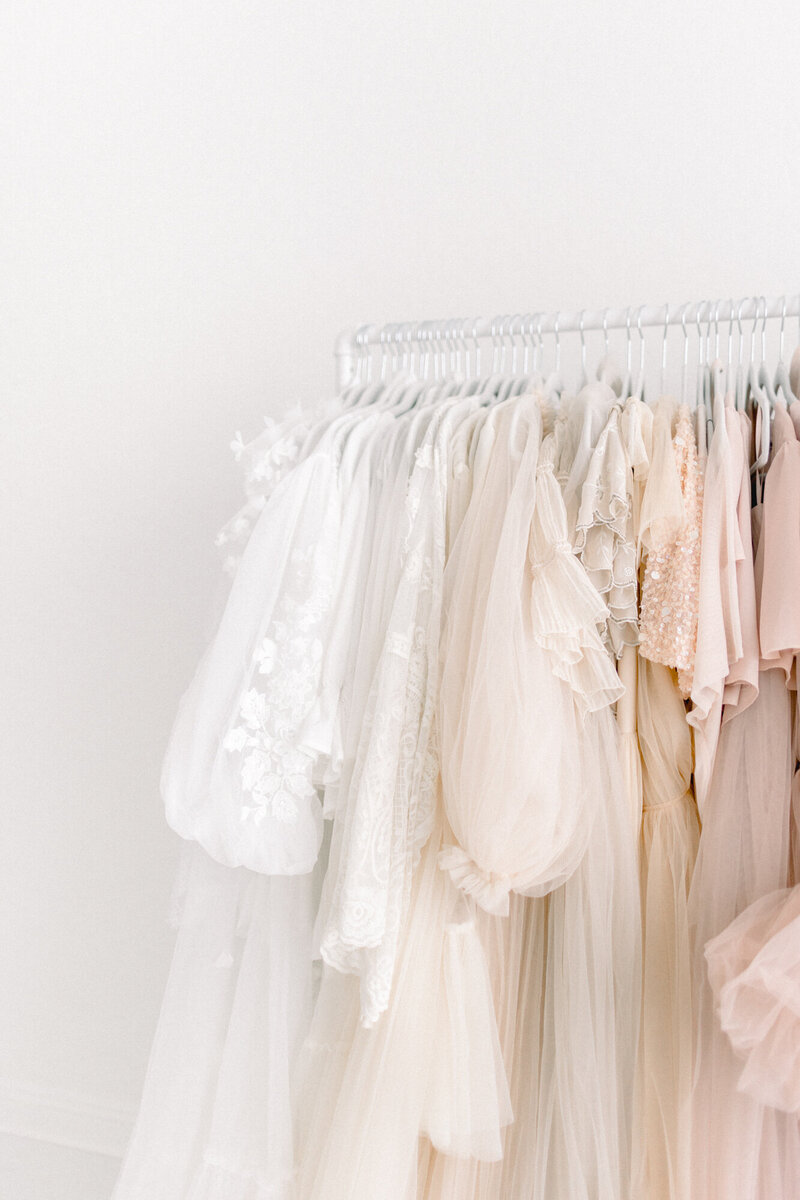 Portrait of a Las Vegas Maternity and Newborn Photographer with a client closet, client wardrobe with gowns and clothing for clients to use for their session.