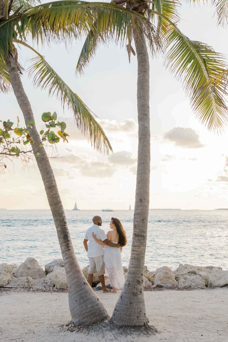 Dallas Fort Worth Photographer engagement photo in Florida, Keys island, posing with his fiance between palm trees