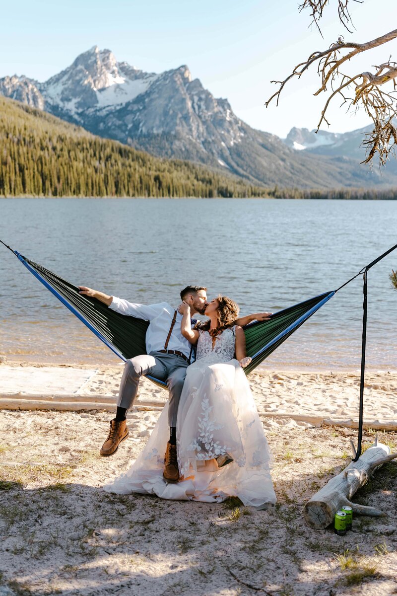 A bride and groom in a hammock after their elopement on the shores of Stanley Lake in Idaho