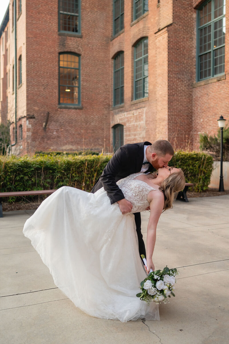 Bride and groom in an outdoor setting deep kiss