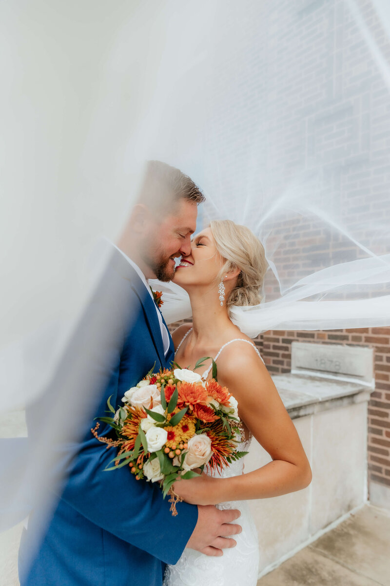 Emotional Midwest wedding portrait of a bride and groom under a flowing veil—ideal for couples searching for a natural light wedding photographer in Michigan or Ohio.