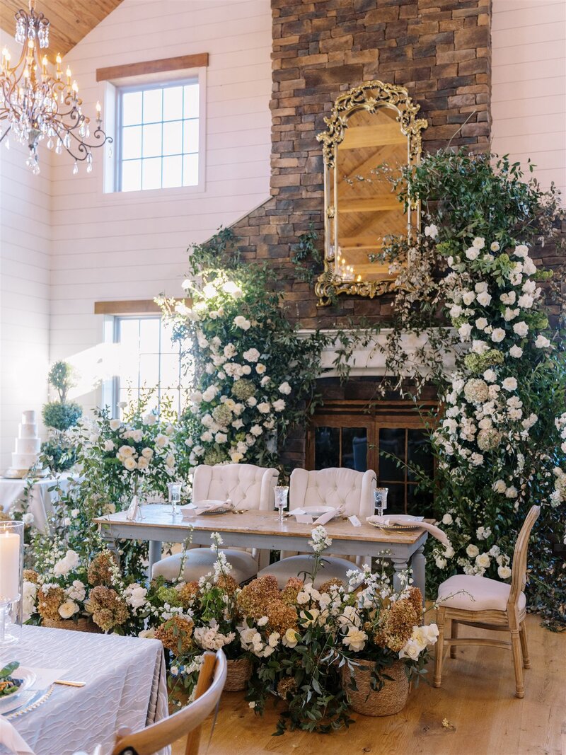 dramatic white flowers with flowing wild vines draping on a large stone mantle and fireplace