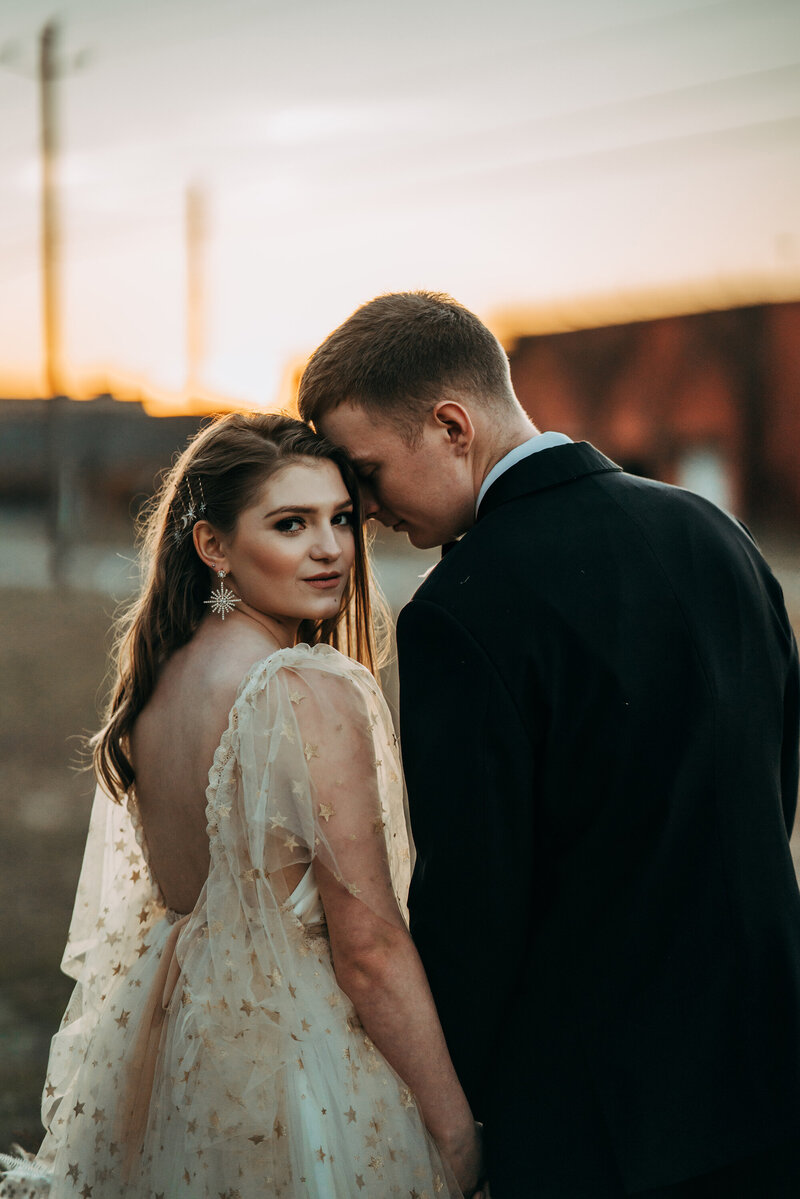 Bride and groom kissing in front of water tower