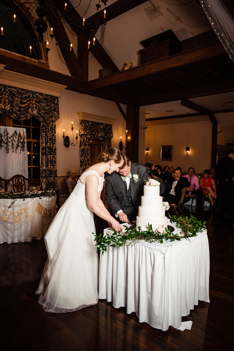 Couple cutting their 4 tier wedding cake on the dance floor during their reception
