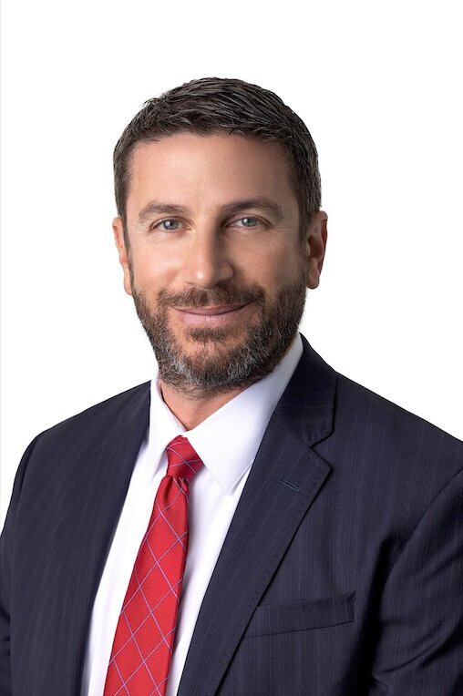 man in tie and suit looking at the camera for a headshot