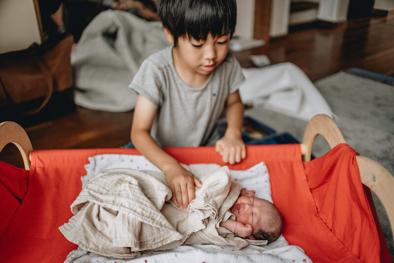 older brother taking care of his newborn sister