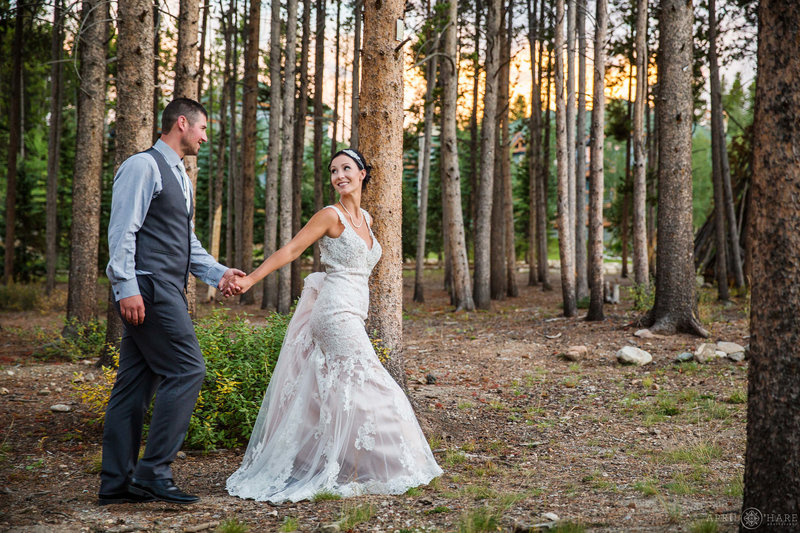 Couple walks through woods at BlueSky Breckenridge Wedding in Colorado
