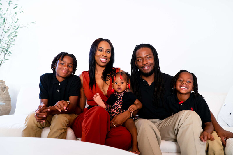 Young black couple with 3 kids sitting on ouch