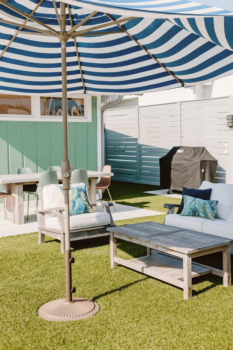 outdoor couch and chairs with striped umbrella