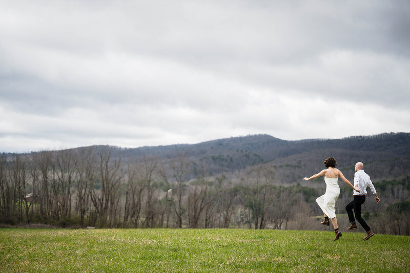 A couple hold hands and begin to skip merrily at Heritage Park in Blacksburg, Virginia on their elopement day.