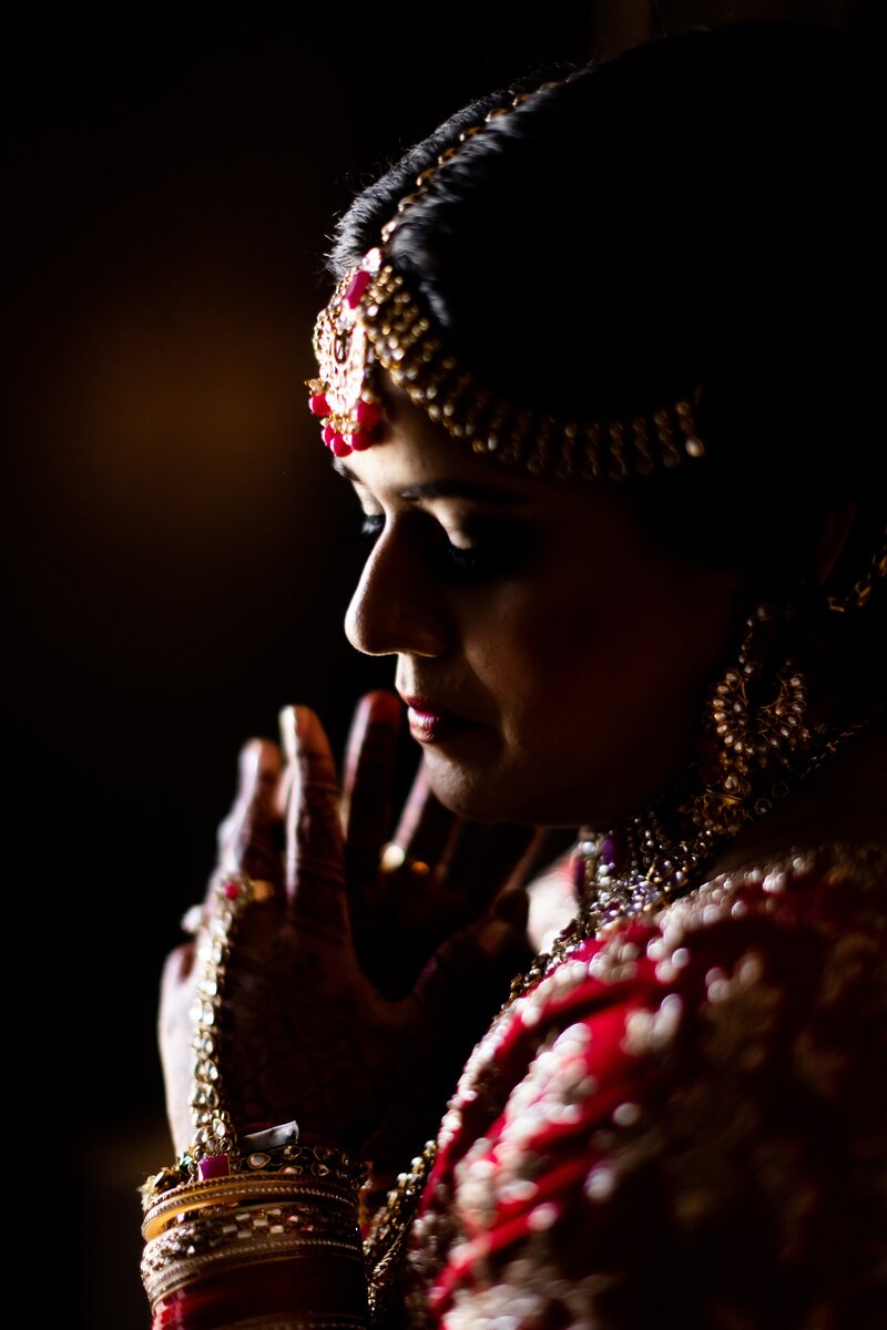 Beautiful Indian Bride with moody lighting and elegant jewelry and details