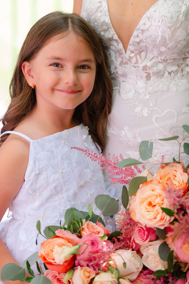 a photo of a flower girl in a white dress with the bride.  Captured by Ottawa wedding photographer JEMMAN Photography