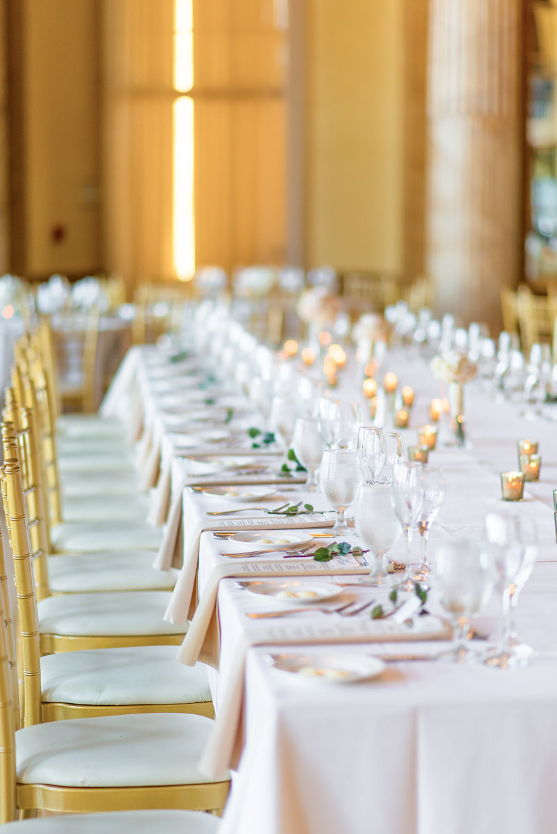 picture of long table with gold accents set for a reception