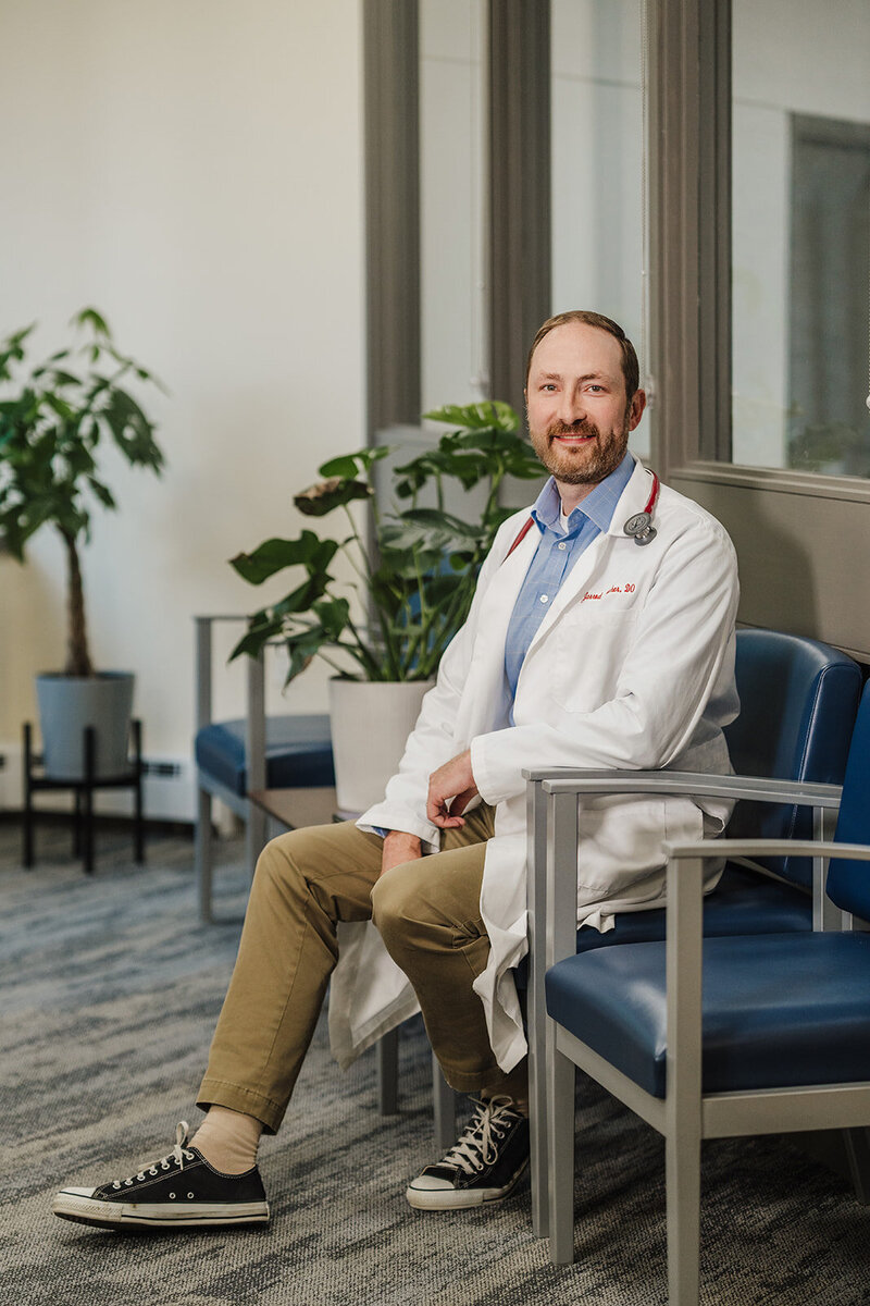 doctor smiles at camera from waiting room in doctors office