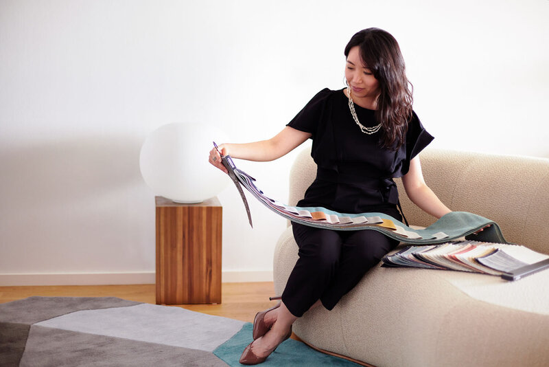 Christen sitting on a designer chair, with colorful cloth patches in hands