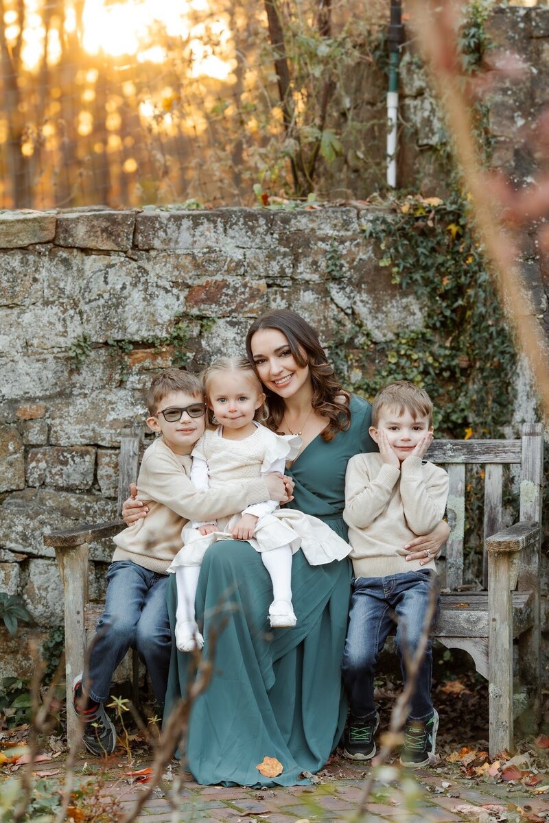 mom wearing a green dress with her 3 children at a new jersey park
