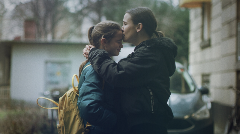 A tense office scene between two main characters, with sharp contrast and backlight.
