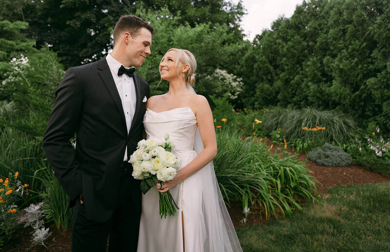 The groom and the bride are walking down the street while holding hands