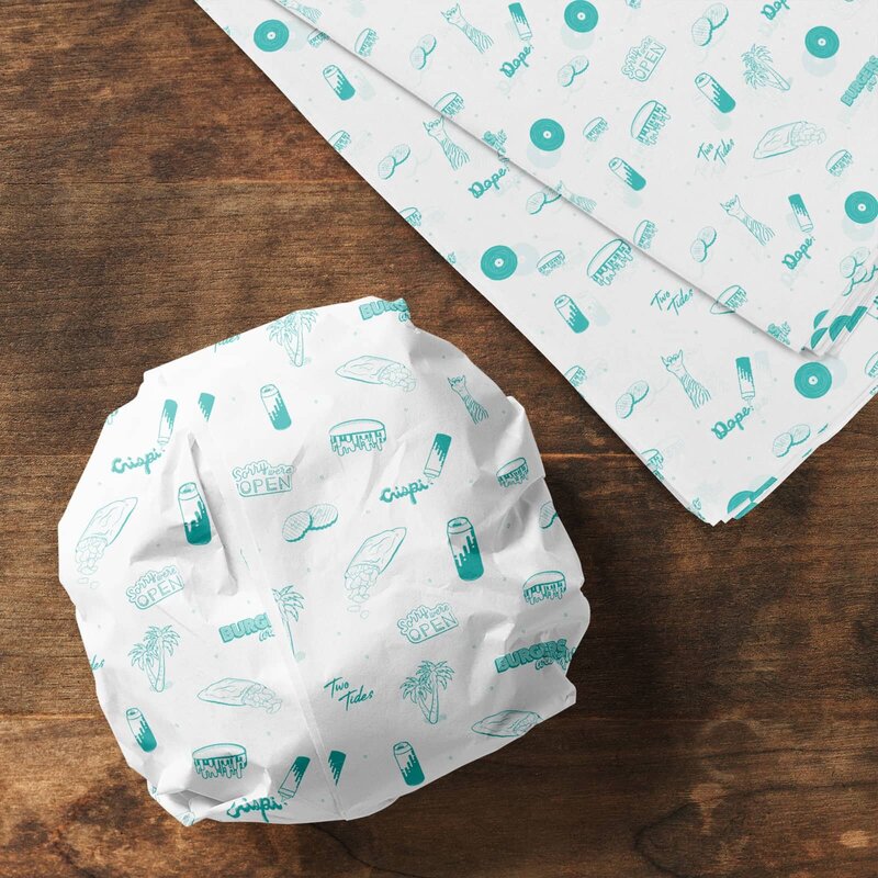 A burger wrapped in deli paper printed with a custom, one-color design