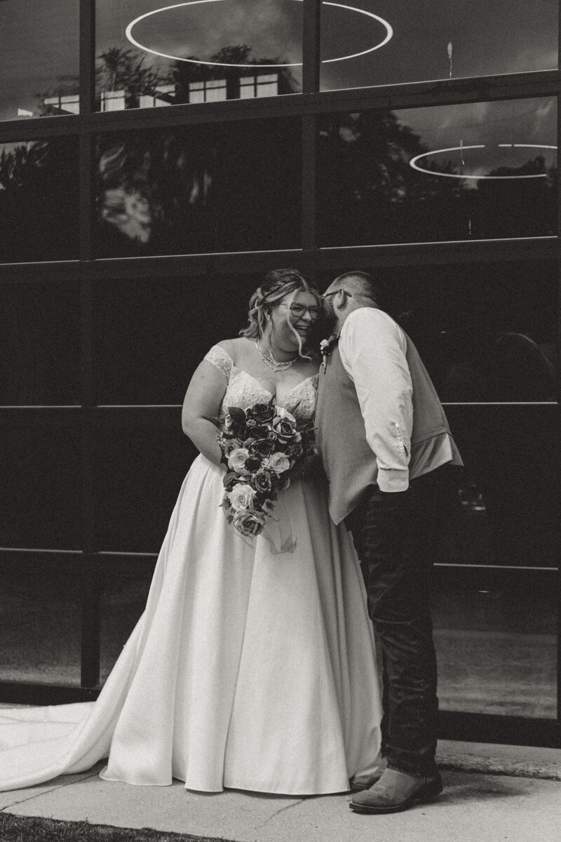 photo of man whispering into woman's ear