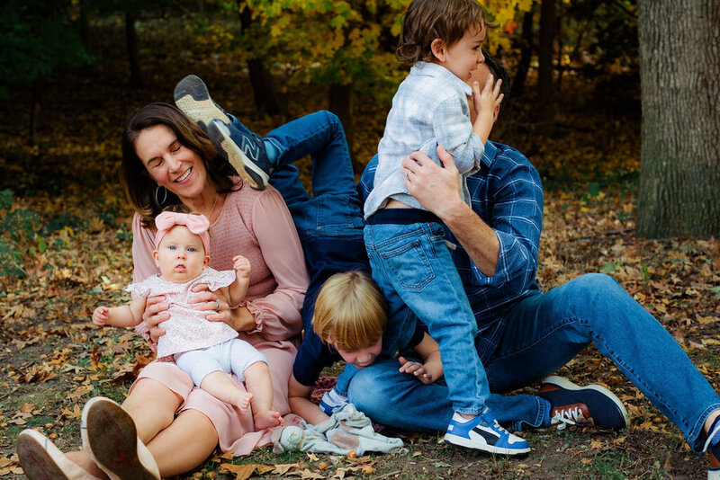 A family laughs outdoors.