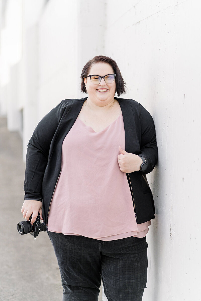 a sacramento wedding photographer poses with her camera.