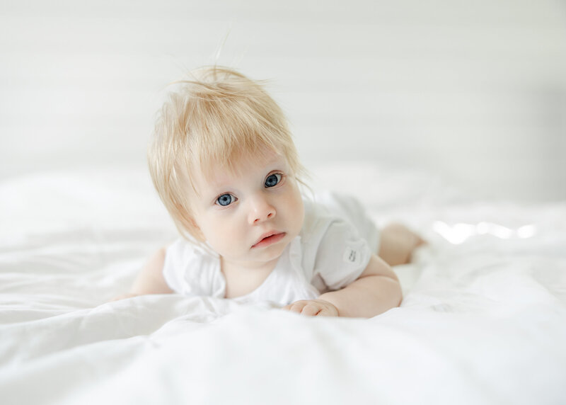 first birthday milestone photo in parent's bed.