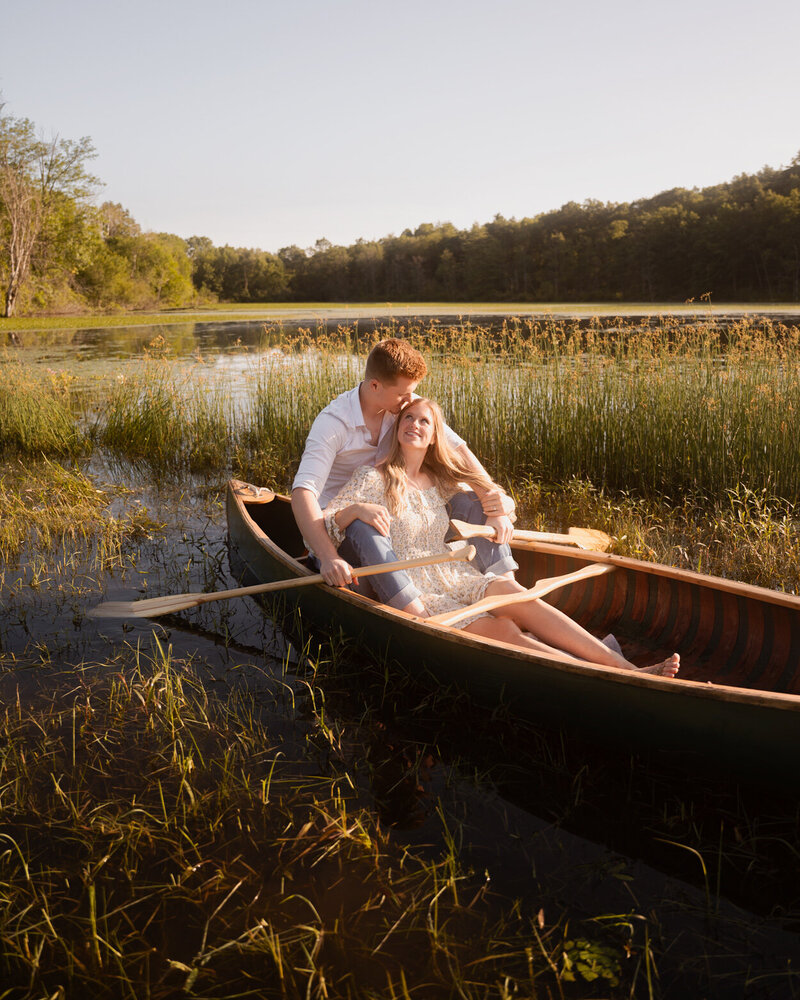 A couple canoeing across the lake during their engagement session near Schuylerville, New York.