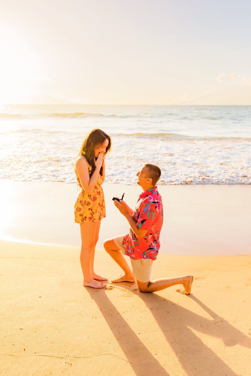 couple wearing bright colors during a Maui proposal at the beach