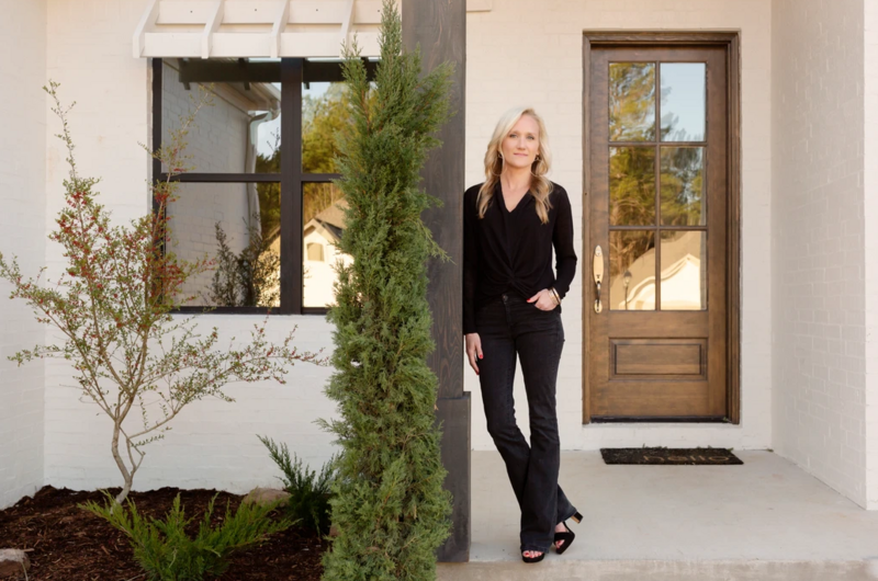 a woman posing outside of a house