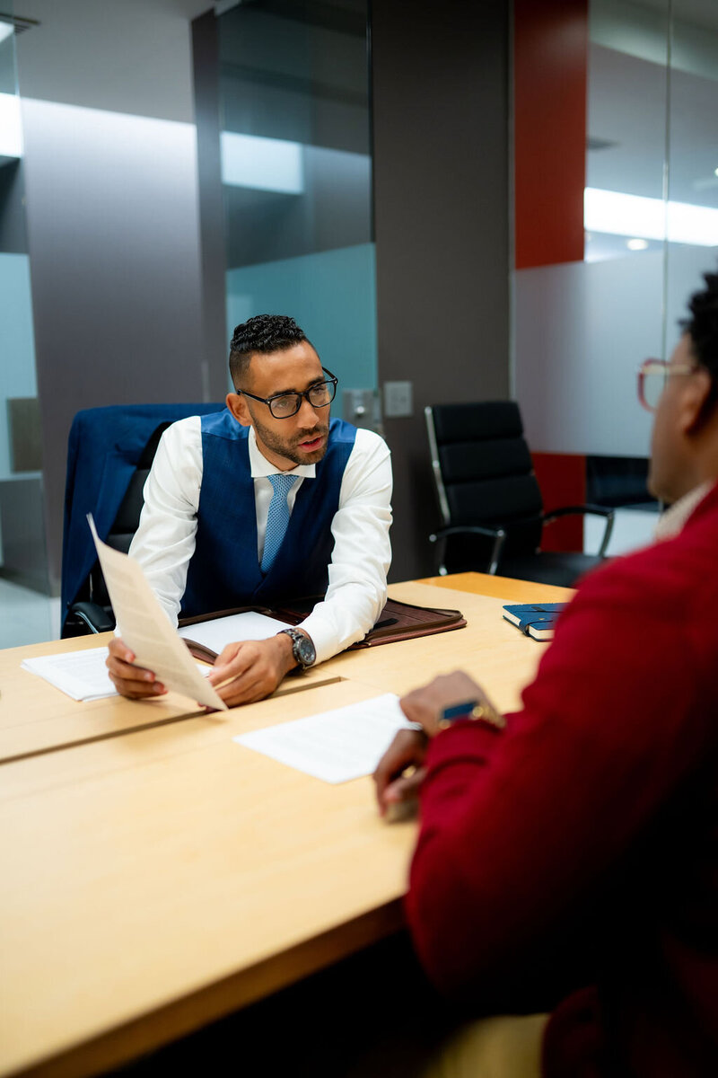 Family law attorney reviewing documents with a client at a desk during a legal consultation.