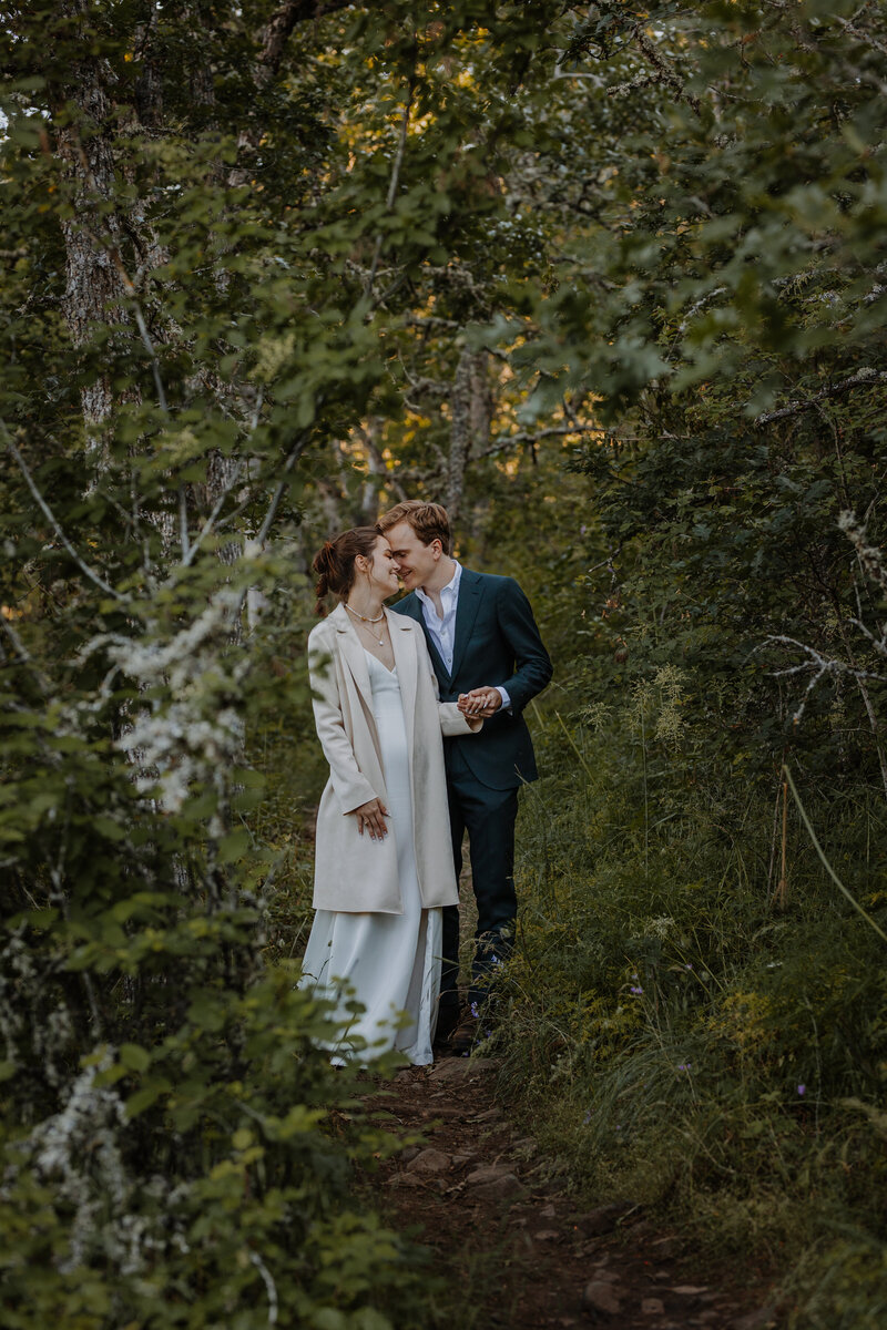 Bride and groom hugging in a forest