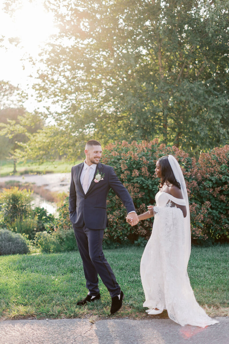 Bride and groom hold hands at golden hour at Glen Ellen Farm