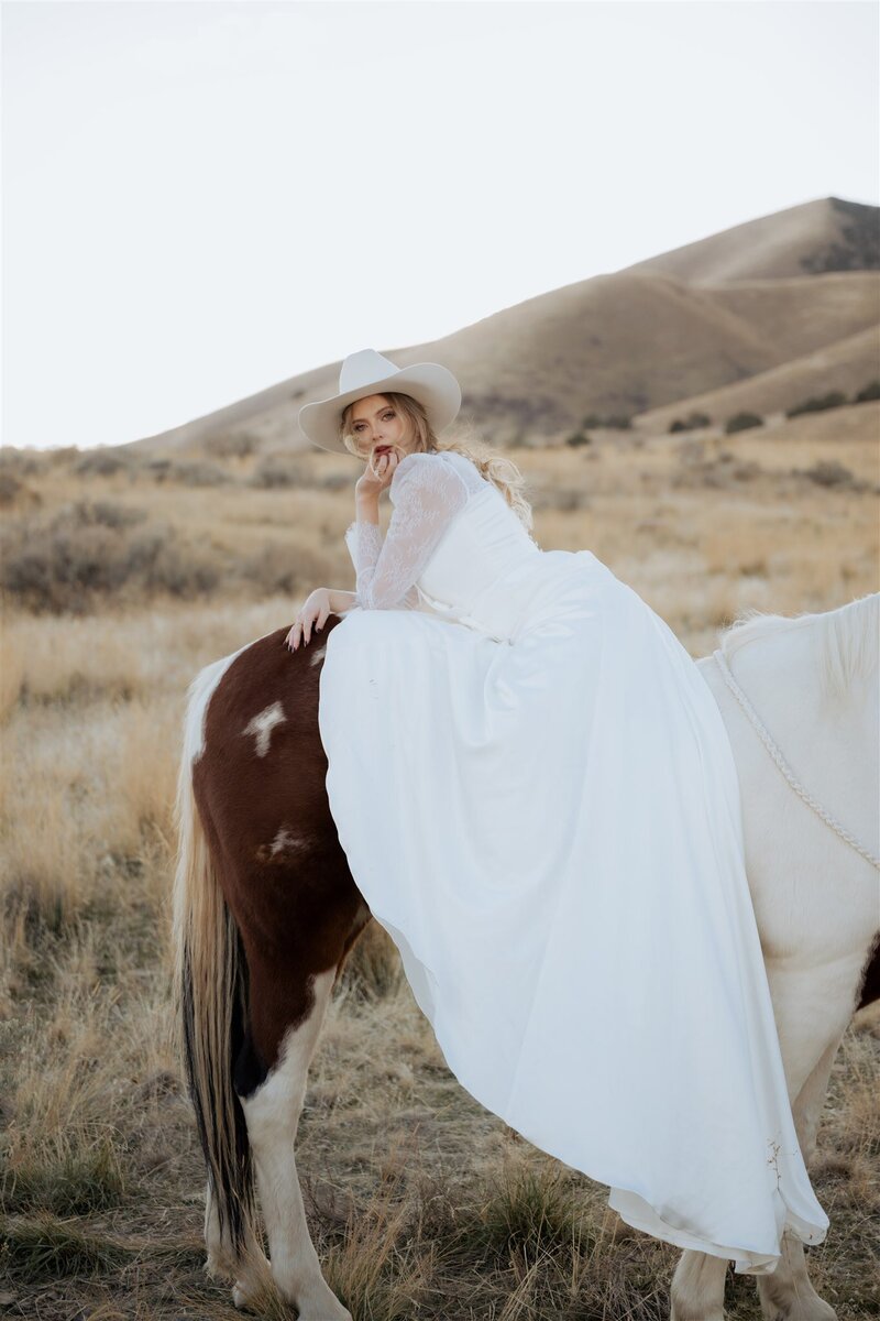 Close up portrait of bride and groom. Groom is wearing a grey suit while the bride is in white with intricate patterns on sleeves.