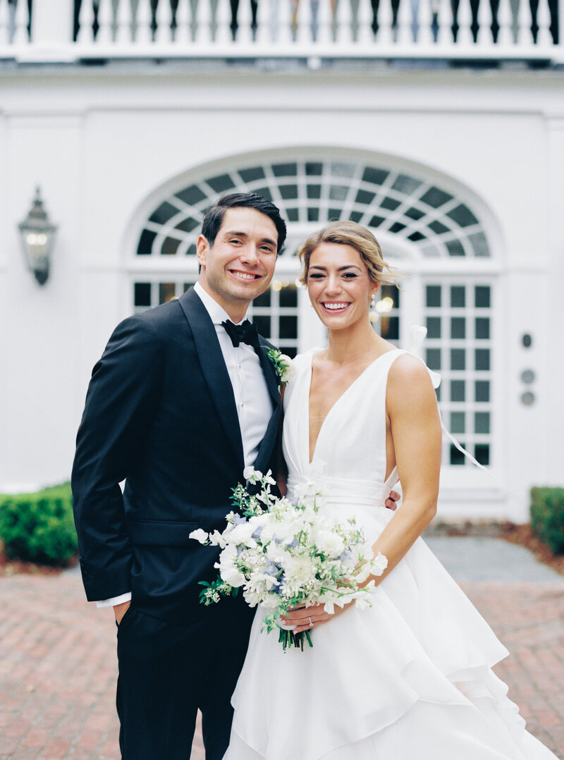 bride and groom standing in front of the house.